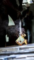 A person is using a metal tool to make a piece of metal photo