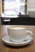 Cup of cappuccino on the table. Cafe. Hot coffee drink. White cup and saucer. photo