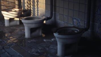 Old and abandoned restroom with three toilet bowls in a dimly lit area video