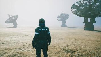 Worker observing satellite dishes in misty environment at a remote location video