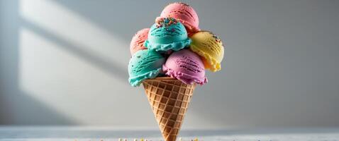 Bright and colorful ice cream scoops in a waffle cone topped with sprinkles. photo
