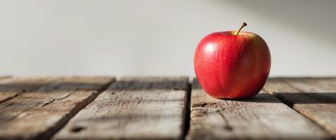 a red apple sitting on top of a wooden tablea red apple sitting on top of a wooden table. photo