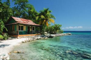 Tropical bungalow overlooking tranquil turquoise bay in the caribbean photo