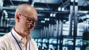Competent professional in data center, solving tasks on tablet while running scripts on laptop terminal. Skillful developer amidst servers, accessing databases and manipulating lines of code, close up photo