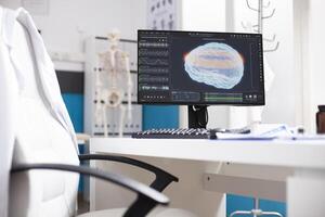 Unoccupied desk with computer screen displaying brain imaging data in doctors office. Modern pc monitor showing radiology results of human head highlighting use of advanced technology in hospital. photo