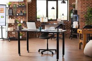 Startup office with modern furniture and company data displayed on screens of digital devices. Indoor decorations include foosball table, plants and water cooler, representing contemporary workspace. photo