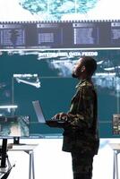 Military personnel operating in a secure office environment, processing critical information and analyzing data on big screen. Maintaining protocols essential for national defense and operations. photo
