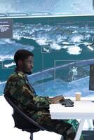 Military officer leads cybersecurity operations in a high tech operation room command post, ensuring data protection. Soldiers working with cctv surveillance systems, satellite imagery. photo