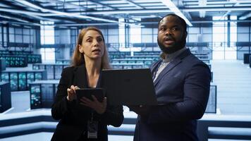 Manager in data center supervising worker running error checking utilities to fix errors. Supervisor in server farm overseeing engineer repairing network issues affecting rigs performance, camera A photo