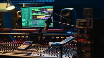 Music recording studio control room with daw software used to mix and master audio tracks, empty soundproof professional space. Modern sliders on control panel board to edit sound waves. photo