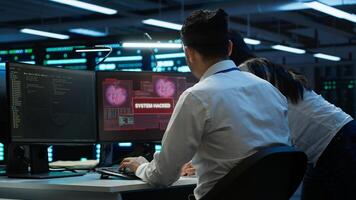 Computer scientists in server room protect hardware from hacker attack stealing sensitive information. Data center cybersecurity division teamworking colleagues fighting security breach, camera A photo