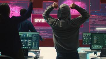 Pleased proud hackers team jumping around after gaining access into rival government database, feeling happy about their success. Professional IT experts hacking network systems. Camera A. photo