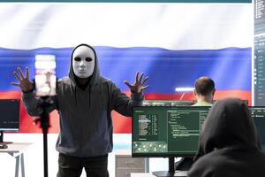 Anonymous person with mask asks for ransom in Russian governmental hacking room with the national flag. Dealing with cyber espionage, disinformation campaigns and hybrid war propaganda. photo