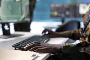 Government intelligence soldier in command center works on surveillance operations, analyze real time data and coordinate security measures. Protection of national interests and efficiency. photo