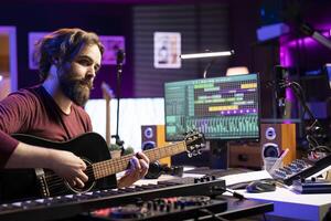 Professional artist teaching guitar lessons on social media web channel, recording himself playing musical instrument accords and explaining strings notes. Young songwriter making tutorials. photo