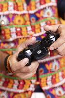 Close up shot of controller used by person playing videogames, studio backdrop. Focus on gamepad used by gamer in burry background participating in multiplayer game using console system photo