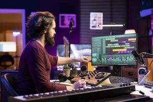 Music producer creating new music with an usb stick in home studio, editing tracks from old audio recordings. Young songwriter composer mixing and mastering tunes, daw software on computer. photo