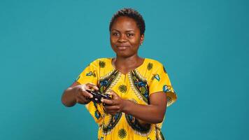 Optimistic confident woman playing videogames on console in studio, having fun with online e sport tournament with a controller. Young gamer enjoys gaming for leisure and relaxation. Camera A. photo