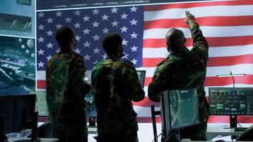 Military personnel work in a high tech environment safeguarding classified data and managing cybersecurity operations to defend against cyber attacks and digital warfare threats. Camera A. photo