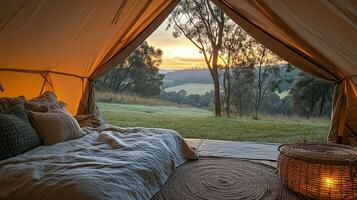 A bed inside a tent with a view of the sunset photo