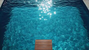 A wooden bench in a pool with a sun shining on it photo