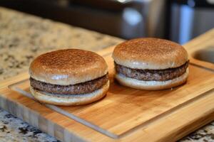 Two hamburgers on a wooden cutting board photo