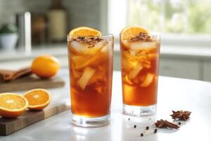 Two glasses of iced tea with orange slices on a counter photo