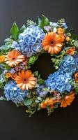 A wreath with blue and orange flowers on a black background photo
