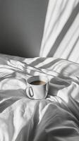 Coffee cup on bed with sunlight photo