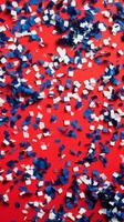 Red, white and blue confetti on a red background photo