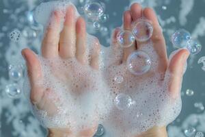 A person's hands are in the water with soap bubbles photo