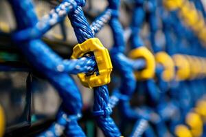 Closeup of blue and yellow rope with yellow plastic rings photo