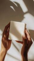 A person holding a soap bar in front of a window photo