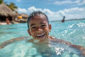 A young boy smiles while swimming in the ocean photo