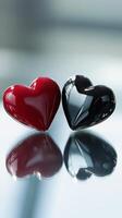 Two black and red hearts on a shiny surface photo