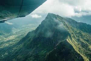An aerial view of a mountain range with a green valley photo
