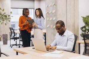 Professional team collaborating, using digital devices in modern workspace, driving innovative solutions and workplace synergy photo