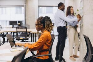 Colleagues collaborating, working individually and together in contemporary workspace, displaying team synergy and creative professional interaction photo