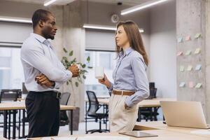 Two managers enjoying a coffee break, engaging in lively discussions and sharing ideas in a vibrant, modern office environment photo