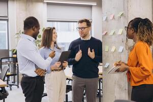 Business team discussing new project ideas using sticky notes on a wall in a modern office photo