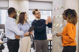 Collaborative team brainstorming project strategy, using multicolored sticky notes in modern bright office environment photo