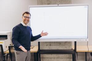 Confident businessman enthusiastically presenting data on an interactive whiteboard in a modern office setting, conveying success and innovation photo