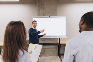 Corporate team analyzing data on digital screen, strategizing together in sleek workspace with collaborative interaction photo