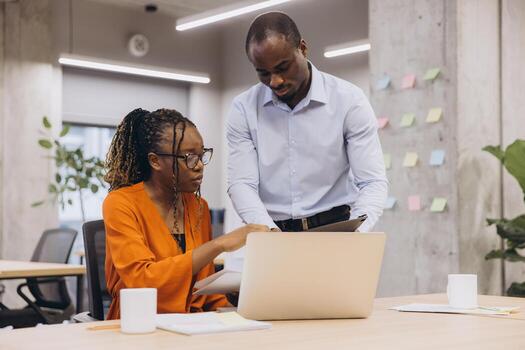 African american professional team collaborating on project, working together with modern technology in bright, open workspace, highlighting creativity and teamwork photo