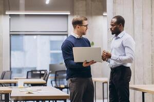Businesspeople conversing near large windows, sharing insights in modern workspace with natural light and sleek design photo