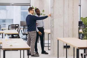 Two professionals discussing ideas in a contemporary office environment, highlighting teamwork and diversity in a business setting photo
