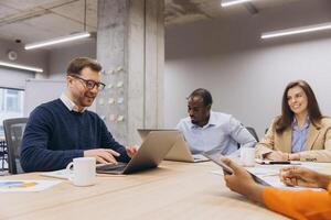 Group of professionals working together in a contemporary office, discussing ideas and using technology for effective collaboration photo