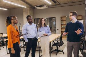 Diverse group of professionals engaging in a collaborative discussion in a modern office setting, highlighting teamwork and business communication photo