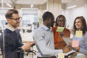 Group of professionals brainstorming with sticky notes in a contemporary office setting, showcasing teamwork and diversity in business photo