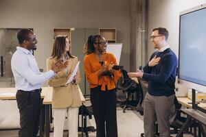 Diverse group of professionals engaging in a collaborative discussion in a modern office environment, showcasing teamwork and innovation photo